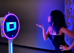 Photo booth setup with ring light and woman taking a selfie
