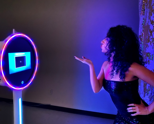 Photo booth setup with ring light and woman taking a selfie