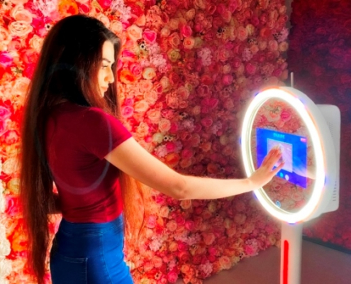 Influencer taking selfie with a ring light photo booth at a retail event