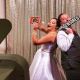 Bride and groom using wedding photo booth props