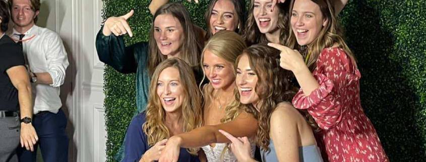 Large-group-of-friends-with-bride-smiling-and-posing-at-a-photo-booth.-Event-and-wedding-services