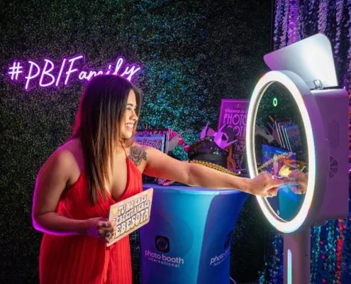 A woman poses with a photo booth at a party